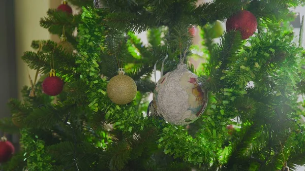 Femmes mains décorant sur l'arbre de Noël avec des boules colorées — Photo