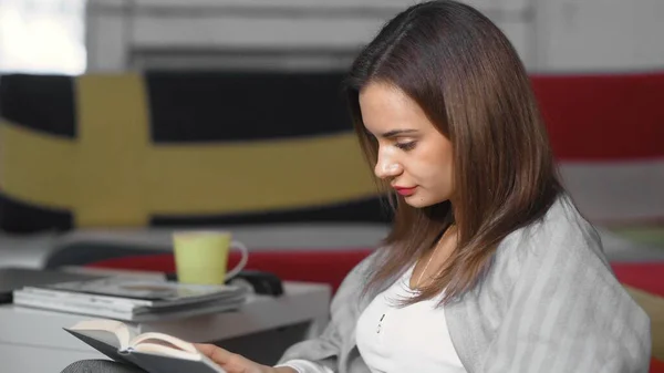 Close up of Woman reading a book and sitting on sofa — Stock Photo, Image