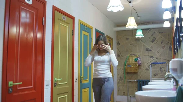 Genç bir kadın pansiyonun tuvaletinde gözlerini ovuşturuyor. — Stok fotoğraf