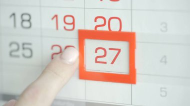 Ofisteki kadınlar duvar takvimindeki tarihi değiştirirler. 27