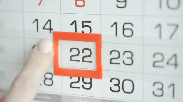 Kvinna hand i kontor ändrar datum på vägg kalender. 22 — Stockfoto