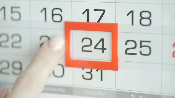 Kvinna hand i kontor ändrar datum på vägg kalender. 24 — Stockfoto