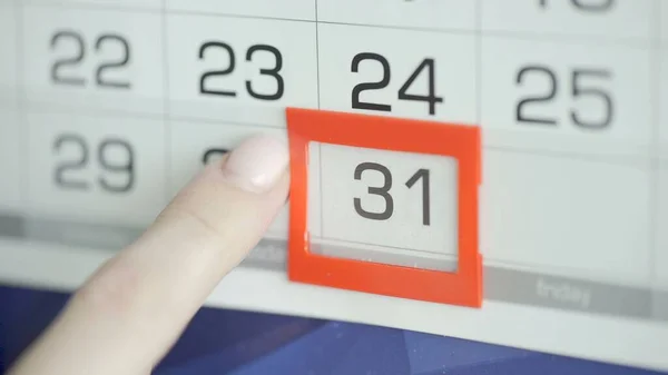 Kvinna hand i kontor ändrar datum på vägg kalender. 31 — Stockfoto