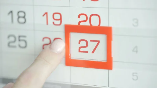 Kvinna hand i kontor ändrar datum på vägg kalender. 27 — Stockfoto
