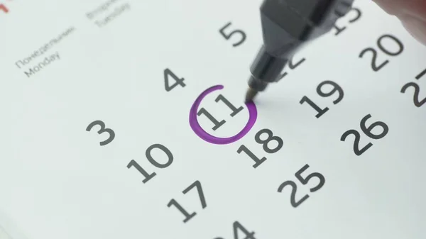 Kvinna hand cirkel dag på papper kalender. 11:e dagen i månaden — Stockfoto