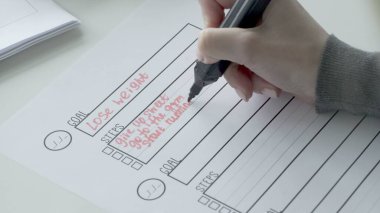 Hedef listesinde kırmızı işaretli adımlar yazan kadın.