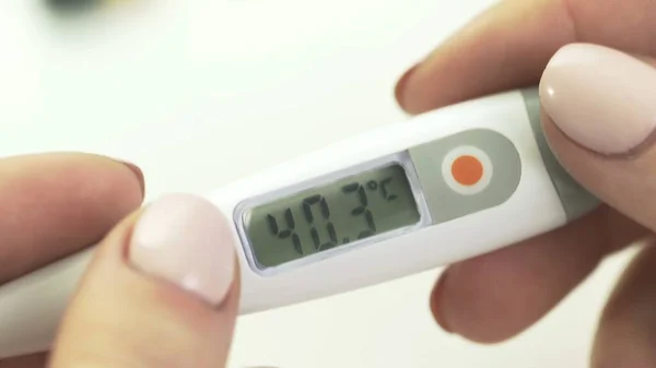 Diaaufnahme des medizinischen Digitalthermometers in Frauenhänden 40,3 — Stockfoto