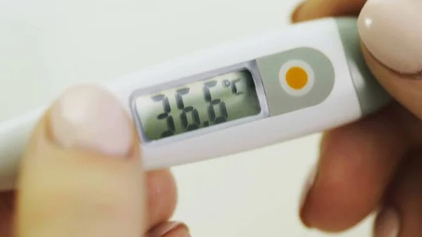 Medical digital thermometer in womans hands