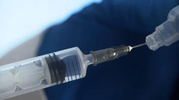 Detailní záběr injekční stříkačky nasává lékařskou tekutinu z plastové ampule — Stock fotografie