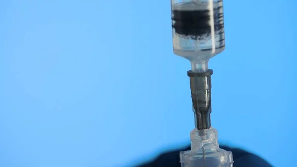Makroaufnahme der Spritze saugt eine medizinische Flüssigkeit aus einem Plastikampulle ein — Stockfoto