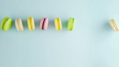 Tatlı renkte badem kurabiyeleri ya da pastel mavi arka planda makaron.