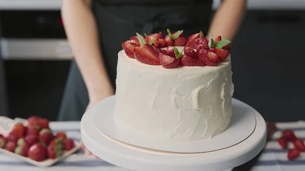 Koektaart thuis. Close-up van mooie witte taart met aardbeien op de top in een moderne keuken — Stockfoto