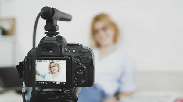 Üstünde mikrofon olan video kamera kadın blogcunun videosunu kaydediyor