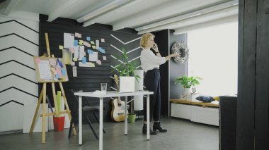 İş kadını, modern ofisteki yolu telefonla açıklıyor.