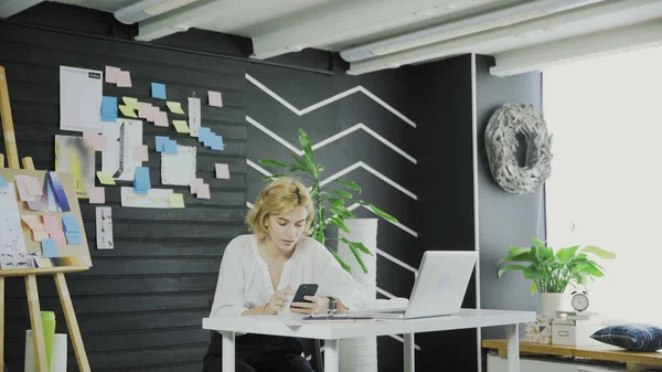 Attractive business woman uses the cell phone in modern office. — Stock Photo, Image