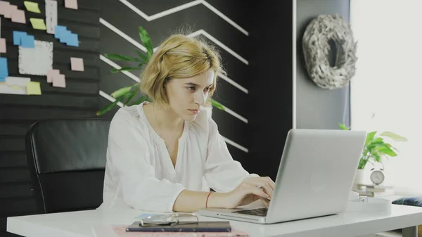 Young businesswoman works on notebook in modern office — Stock Photo, Image