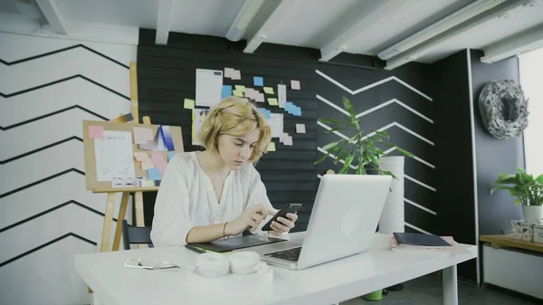 Woman designer working uses phone on the table — Stock Photo, Image