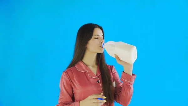 Attraktive junge Mädchen im Schlafanzug trinken Milch — Stockfoto
