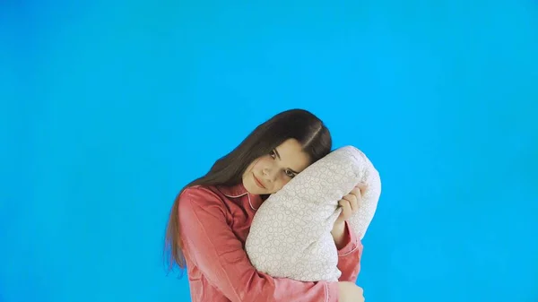 Young pretty girl with pillow on blue Background in Studio — Stock Photo, Image