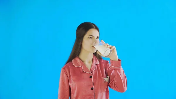 Приваблива молода дівчина в піжамі п'є молоко — стокове фото