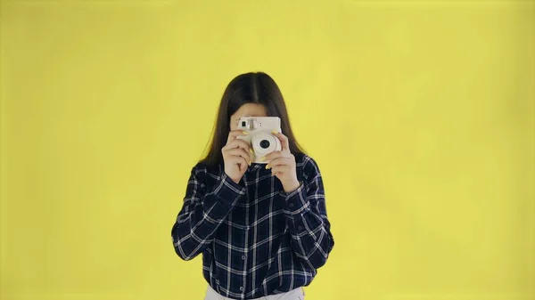 Genç bir kadının portresi Stüdyoda sarı arka planda Retro Kamera kullanıyor. Fotoğraf Çeken Genç Kadın. — Stok fotoğraf