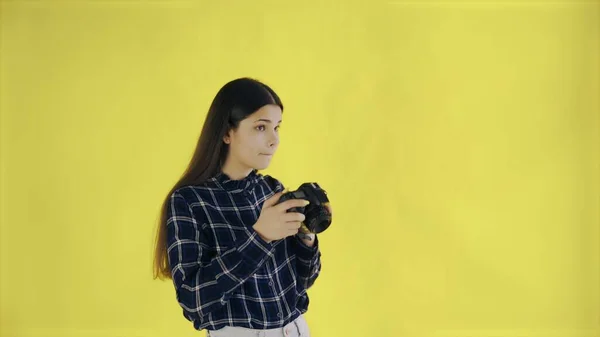 Молода жінка фотографується на жовтому тлі в студії — стокове фото