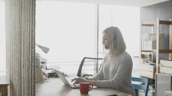 Online technical support worker. Blonde woman with headphones on head — Stock Photo, Image