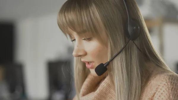 Female customer service representative talking with customer with headphones — Stock Photo, Image