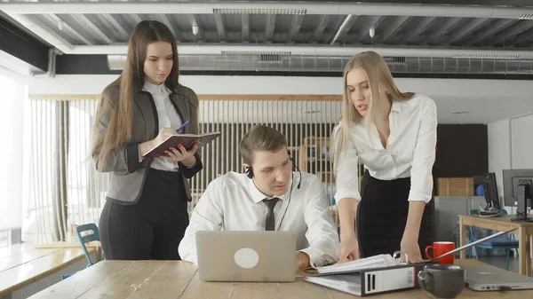 Attractive female managers are talking to their subordinate. One woman point to document folder, another woman make a note — Stock Photo, Image