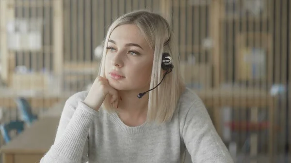 Online technical support worker. Blonde woman with headphones on head — Stock Photo, Image