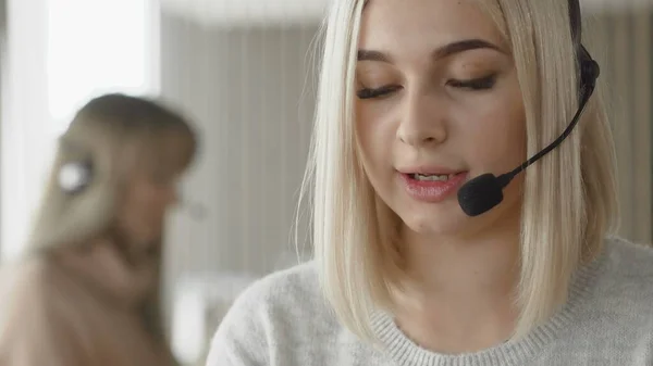 Two female call centre support specialist talking with customers by headsets. — Stock Photo, Image