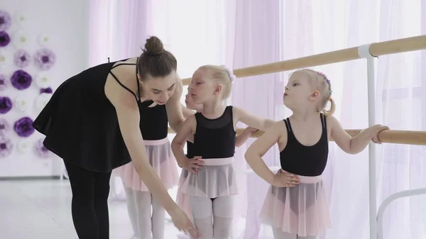 Группа маленьких девочек изучает новые танцевальные движения во время урока балета — стоковое фото