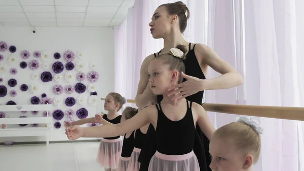 Pequenas bailarinas em leotards roxos treinando no barre . — Fotografia de Stock