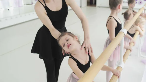 Ballettlehrerin zeigt Kleinkindern Tanzposition. — Stockfoto