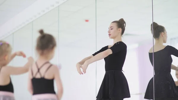 Carino insegnante di balletto femminile sta insegnando una lezione alle bambine — Foto Stock