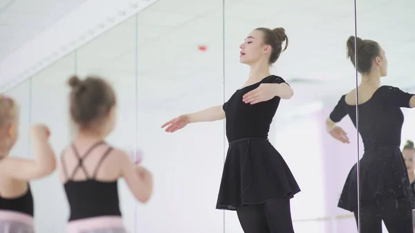 Bonito professor de balé feminino está ensinando uma lição para meninas — Fotografia de Stock