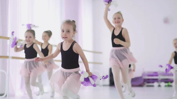 Kleine meisjes met speelgoed in handen rennen in ballet klaslokaal — Stockfoto