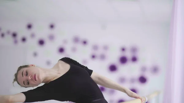 Professional ballet dancer practicing near a ballet bar. — Stock Photo, Image