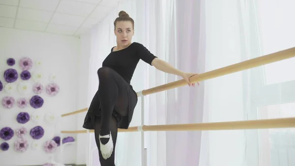 Ge=ballerina vestida com tutu preto dançando perto de uma grande janela . — Fotografia de Stock