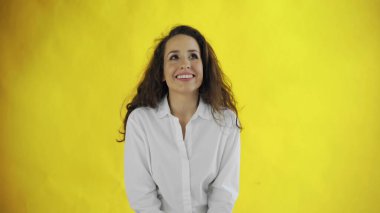 Sarı arka planda zevk duyguları olan genç kadın portresi.