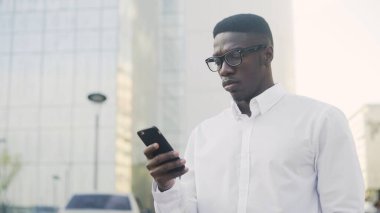 Çevrimiçi telefonda sohbet eden Afrikalı çekici iş adamı.