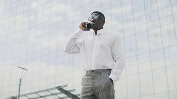 African American Businessman talking on cell phone, standing near his office — Stock Photo, Image