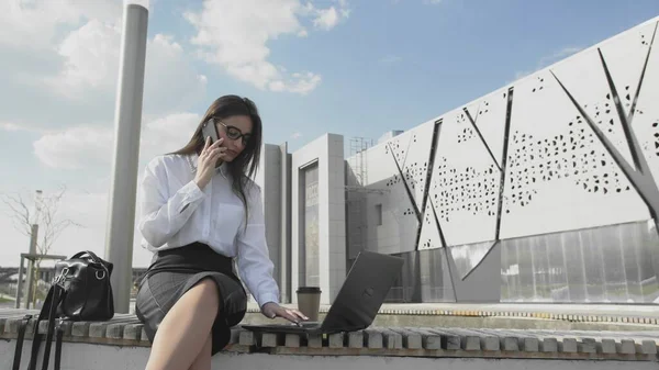 Successful business woman working with laptop, talking on the mobile phone — Stock Photo, Image