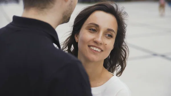 Portrait of attractive couple standing at the city street talking and smiling — Stock Photo, Image