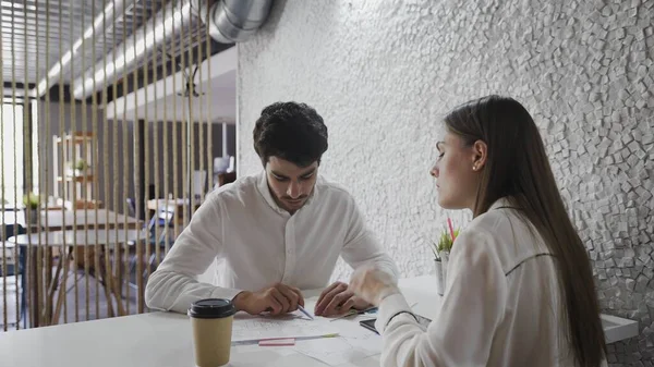 Young experts are working and talking at table in leading company indoors. — Stock Photo, Image