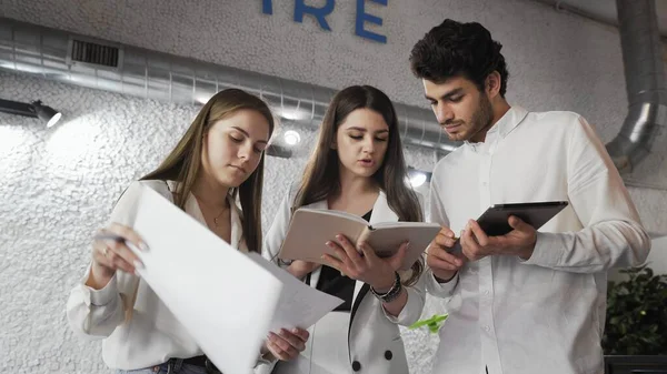 Thee Young Business People discutiendo el proyecto en la oficina . — Foto de Stock