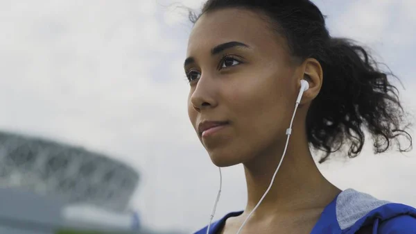 Close up de mulher afro-americana com fone de ouvido para motivação musical para treinamento cardio prepara-se de corrida — Fotografia de Stock