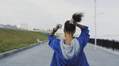 Dişi koşucu koşmaya ve saçını bağlamaya hazırlanıyor.