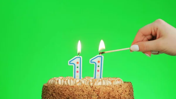 Зажигание свечи дня рождения номер четыре на вкусном торте, зеленый экран 11 — стоковое фото