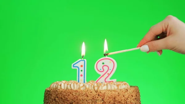 Iluminando uma vela de aniversário número quatro em um delicioso bolo, tela verde 12 — Fotografia de Stock